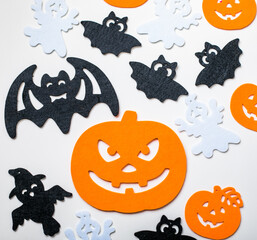 Frame of halloween decoration on pastel white background. Flat lay orange pumpkins, spooky spiders, bat, insects. Top view with copy space. Holiday greeting card mockup.