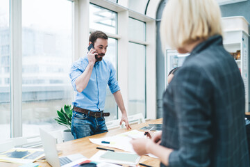 Man speaking on smartphone standing in workplace