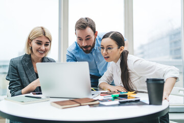 Obraz premium Smiled freelancers browsing laptop and stationery at cafe
