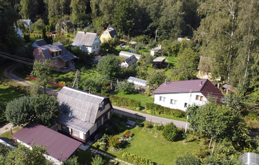 Fototapeta na wymiar Top view of suburban villas near the park. Landscape with roofs of small houses