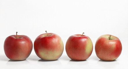 Fresh apples in a row. White background. side view