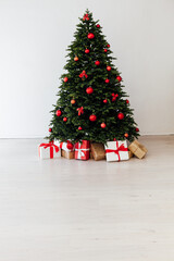 Christmas tree pine with red decor with gifts interior postcard for the new year