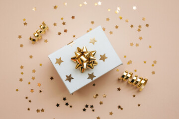 Gift box on a pink background with golden confetti. Festive background.