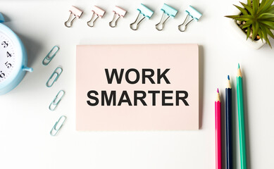 WORK SMARTER text written on a notebook with pencils and graphs.