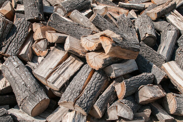 Cut dry oak firewood heap closeup as wooden background