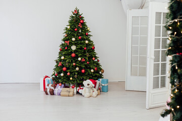 Christmas tree with gifts pine new year decor the interior of the white room of the house postcard