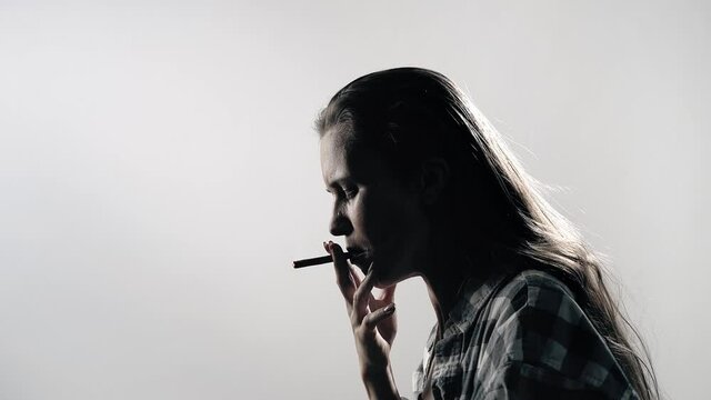 Woman smoking. Silhouette of an upset woman