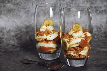 Banoffee sandae in the glass on the dark background