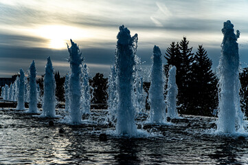 Fountains against the backdrop of the setting sun look like fantastic blocks of ice in winter in a fairyland. Russia, Moscow, Poklonnaya Gora, Victory Park.