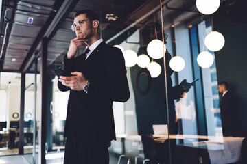 Thoughtful businessman with mobile phone