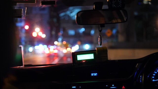 Taxi ride at night in Bangkok city with illuminated taxi meter and blurred street lights, urban transportation and nightlife lifestyle concept