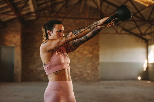 Woman Workout With Kettle Bell Inside Old Warehouse