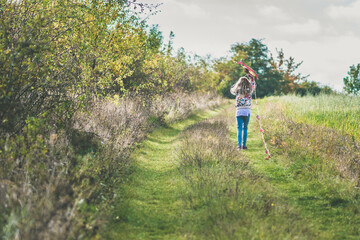 little child playing with colorful kite in rural countryside