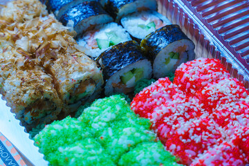Various sushi with sauce and ginger in a disposable plate.