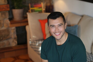 Young ethnic man smiling at home