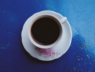 isolated coffee in vintage cup on blue background and photo captured with selective focus