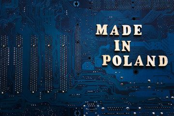 Inscription Made in Poland on a blue electronic printed circuit board. Background with copyspace...