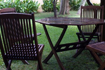 wet wooden table and chairs in the garden on a rainy day