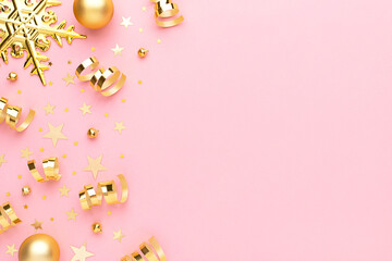 Christmas pink flatly. Many sparkling golden confetti, decorative snowflake and ribbons at pink background. Festive concept.