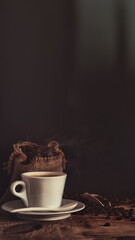 View of hot fresh cup of coffee with coffee beans in jute burlap bag in low light still life photography
