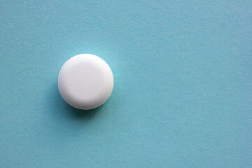 White pill on blue background. View from above of big round tablet. Copy space