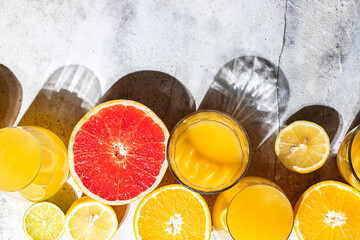 Citrus juice and fresh fruit, lime, grapefruit, orange, lemon in sunlight. Detox drink.