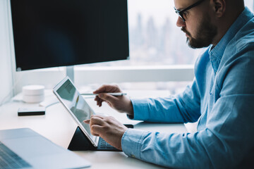 Fototapeta premium Male manager working on modern tablet with stylus