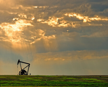 An Oil Rig Punctuates The Open Prairies Of Alberta, Canada