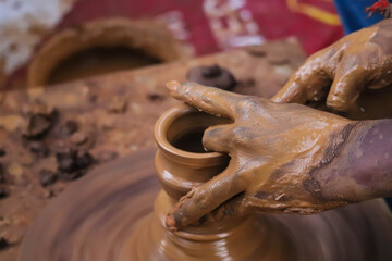 Dirty Hands Of Potter Making Pottery From Mud Using Spinning Potter Wheel