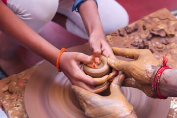 Hands And Fingers Posture Of Potter Helping Training Or Teaching Student How To Making Pottery From Mud Using Spinning Potter Wheel In Workshop