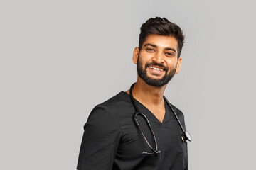 young indian male doctor or surgeon with stethoscope on gray background