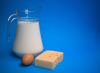 Dairy products. Milk, egg and cheese on a blue background.