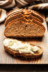 Fototapeta na wymiar Rustic loaf of homemade bread sliced on wooden board