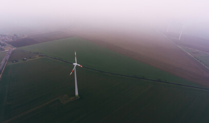Windmill on agricultural field in overcast day
