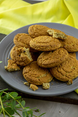 large plate of oatmeal cookies on the table with a branch of eucalyptus