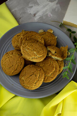 large plate of fresh oatmeal cookies with a yellow accent