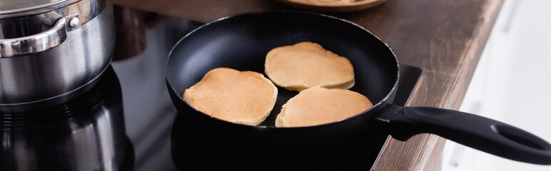 Website header of pancakes on frying pan on stove