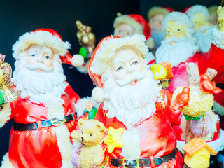 Decorative figurine of Santa with gifts on the background of other figurines. Close-up photo with focus in the foreground