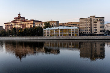 Fototapeta na wymiar river embankment of a large metropolis at dawn with reflections in the river