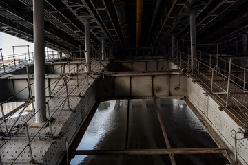 vintage road bridge with metal riveted sheet base across the river at sunrise