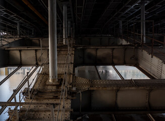 vintage road bridge with metal riveted sheet base across the river at sunrise