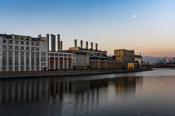 river embankment of a large metropolis at dawn with reflections in the river