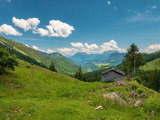 Fototapeta na wymiar Austrian mountain landscape with blue sky background and a small shed