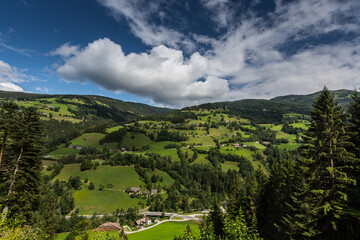 green nature landscape with white clouds and blue sky