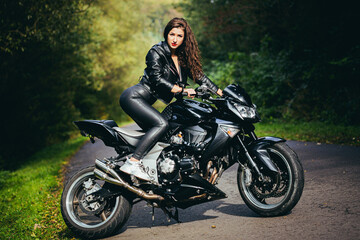 Naklejka na ściany i meble Biker sexy woman sitting on motorcycle. Outdoor lifestyle portrait