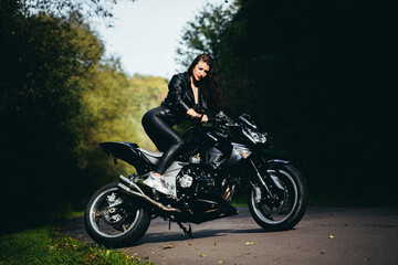 Fototapeta na wymiar Biker sexy woman sitting on motorcycle. Outdoor lifestyle portrait