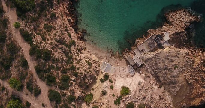fishing Huts, Ibiza coastline, Balearic Islands, Cala Tarida cliffs and beach, stunning aerial footage of  the mediterranean sea