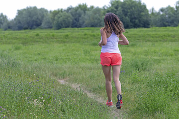 Young woman running in nature on a rural road