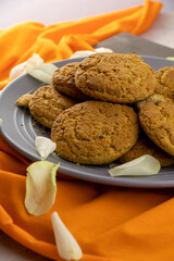 large plate of oatmeal cookies with rose petals