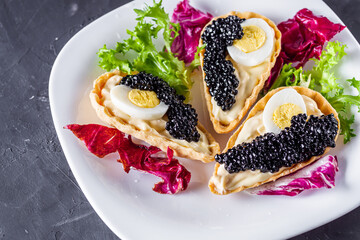 delicious snack tartlets on dark stone background